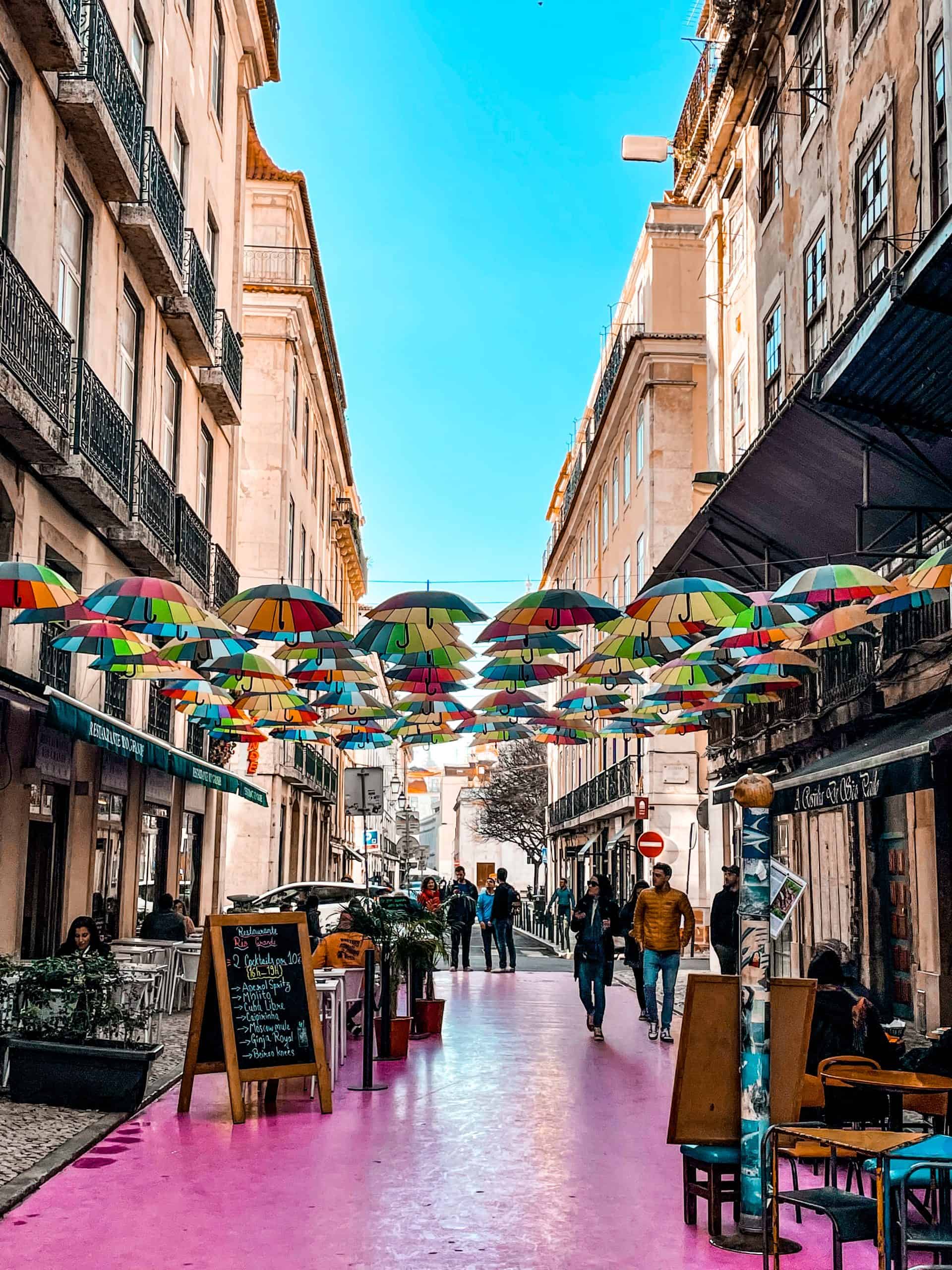 Explore the pink street in Lisbon, Portugal and see the rainbow umbrellas