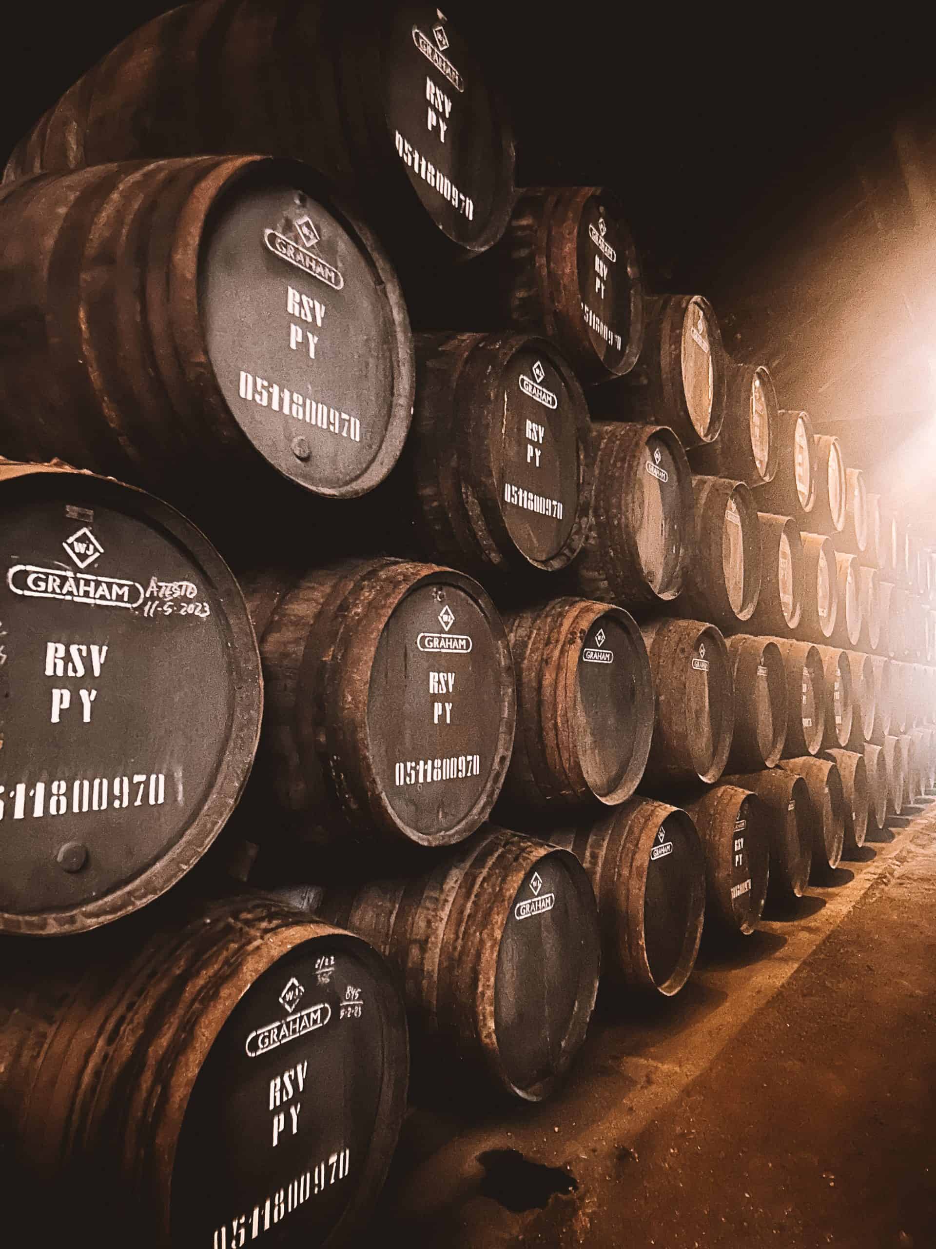 Dark brown wine barrels at a winery in Porto, Portugal.