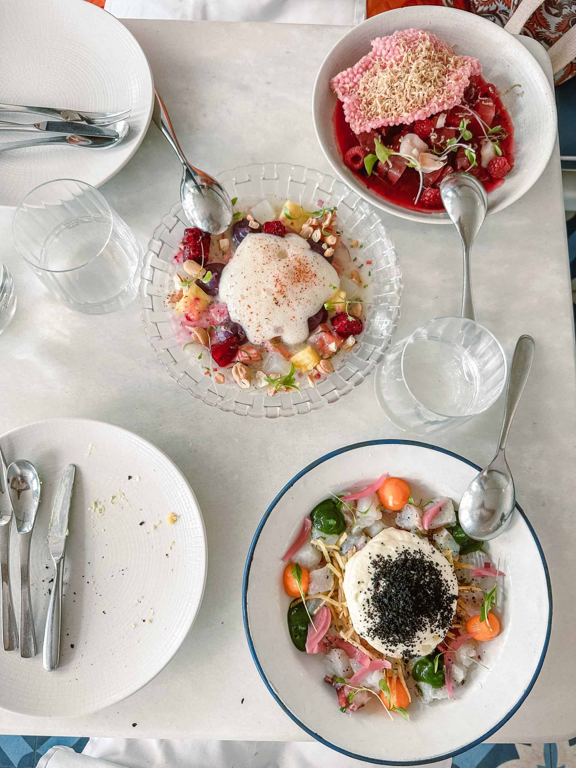 Colorful ceviche in white bowls on a white table at a top restaurant in Lisbon, Portugal