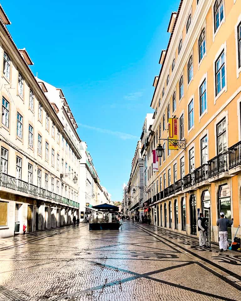 5 Days in Lisbon Empty plaza on a sunny morning with yellow and beige buildings in Lisbon, Portugal.