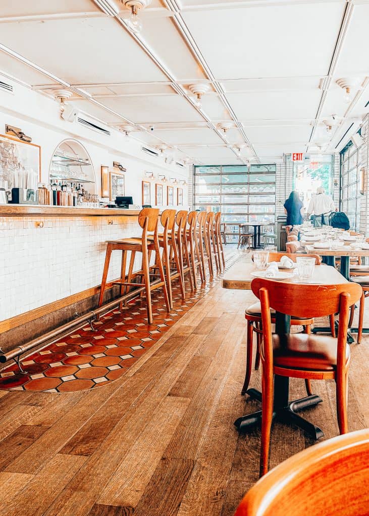 Cute airy restaurant with white brick and brown wood at La Pecora Bianca, an Italian restaurant in New York