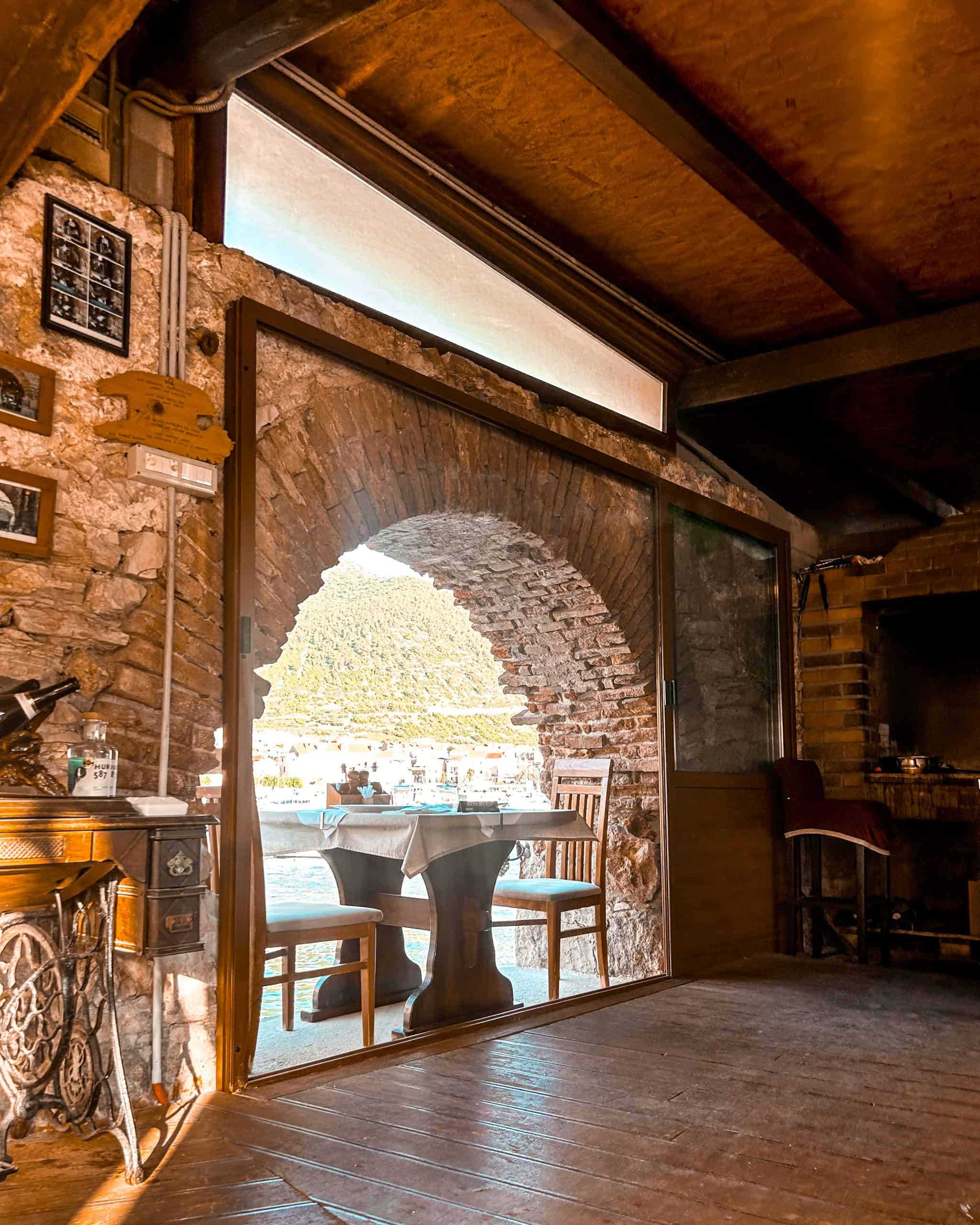 9 days in Croatia table and chairs against a brick archway at an outdoor restaurant in Vis, Croatia