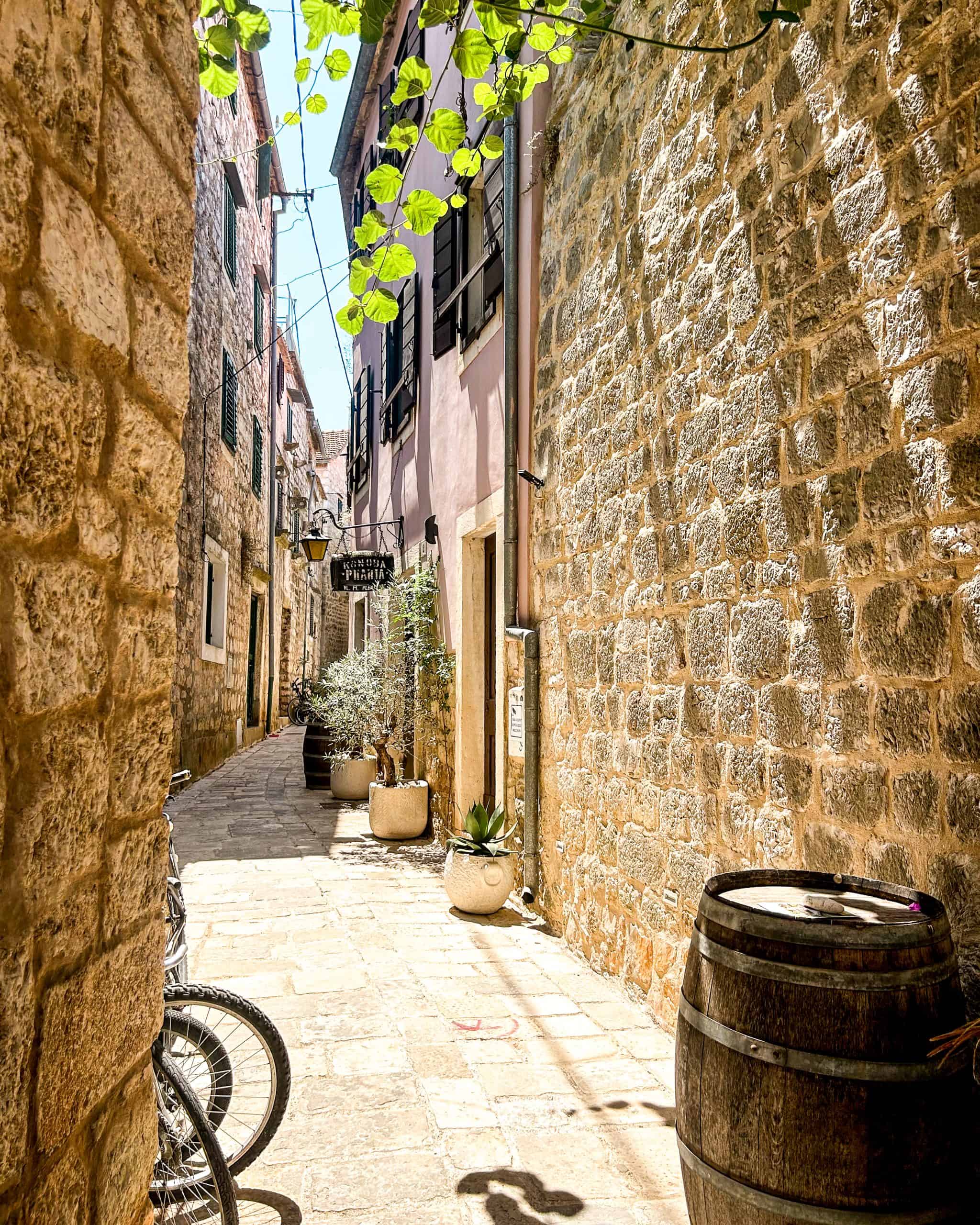 Is Croatia worth visiting? A narrow alley with plants and bikes in the Old Town in Hvar, Croatia