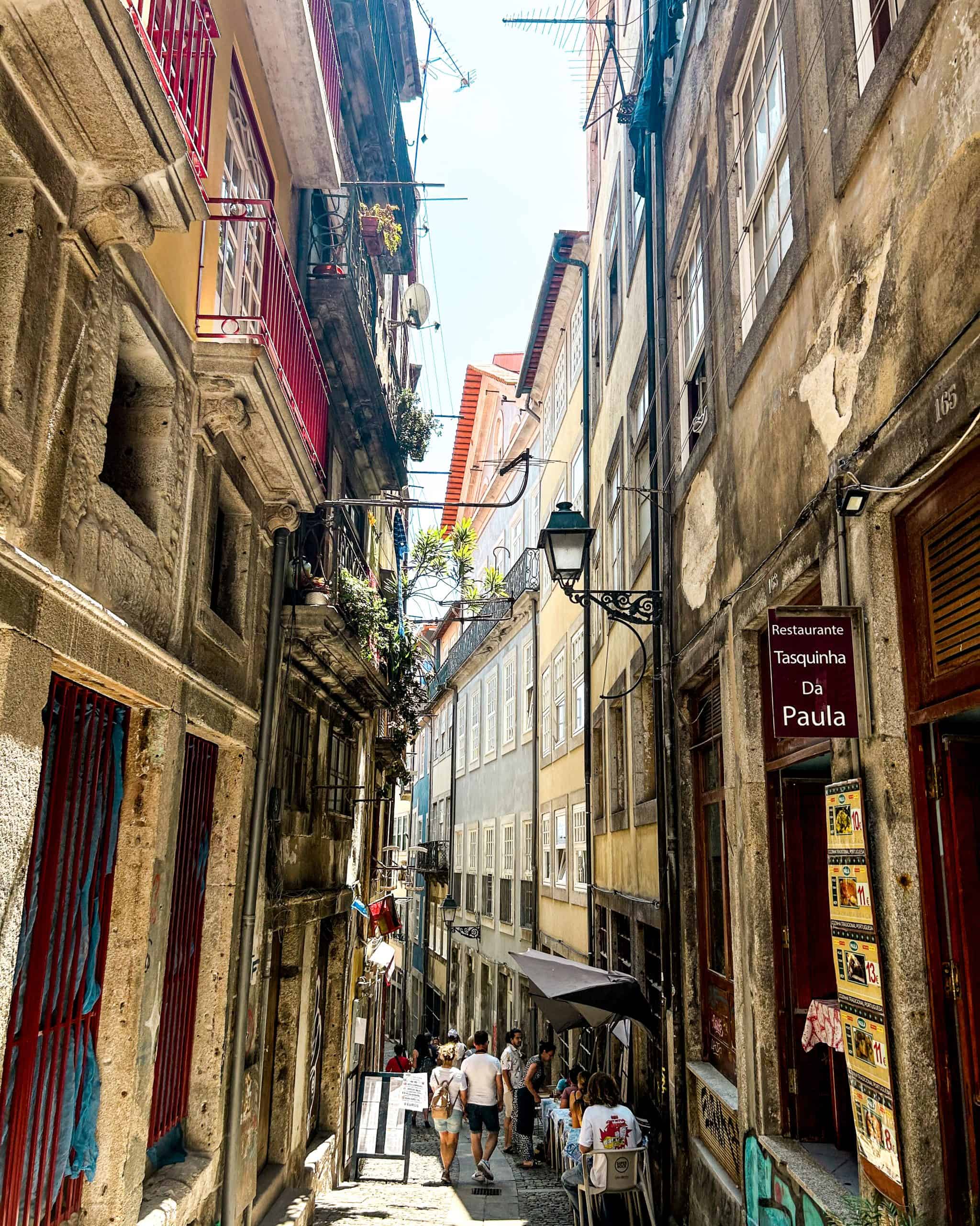 narrow alleyway featuring colorful buildings and historic architecture in Porto, Portugal