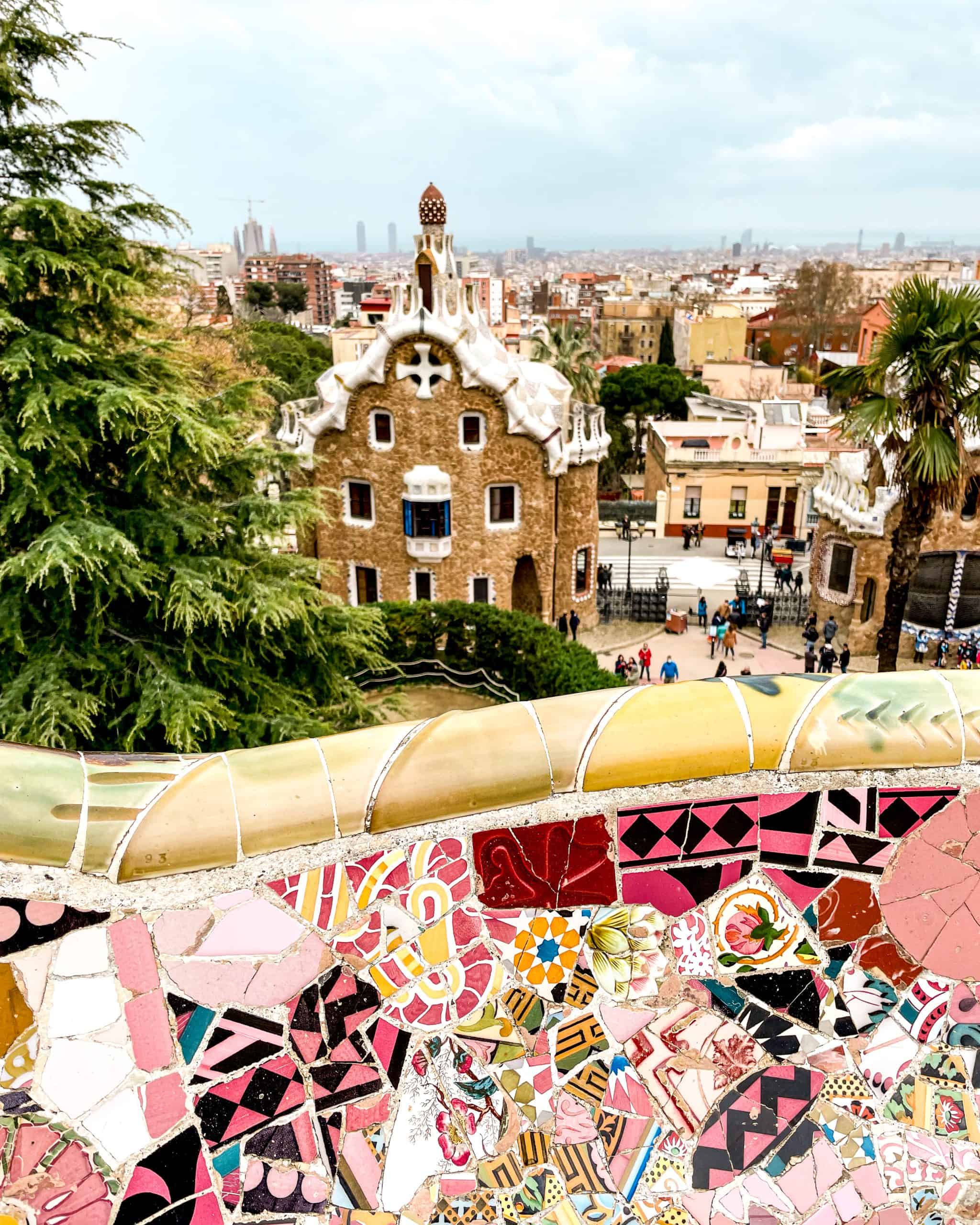 tiled wall and unique architectural building in the background at the Park Güell in Barcelona, Spain