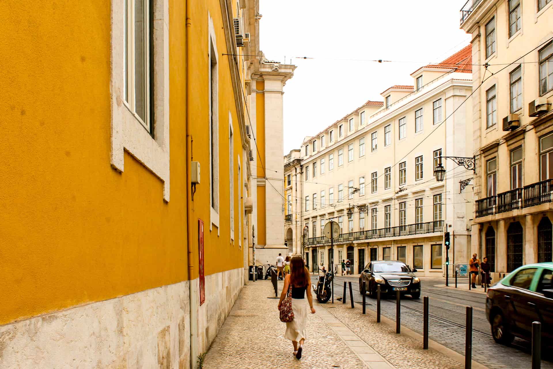 Where to stay in Lisbon young woman walking down the street in Lisbon, Portugal