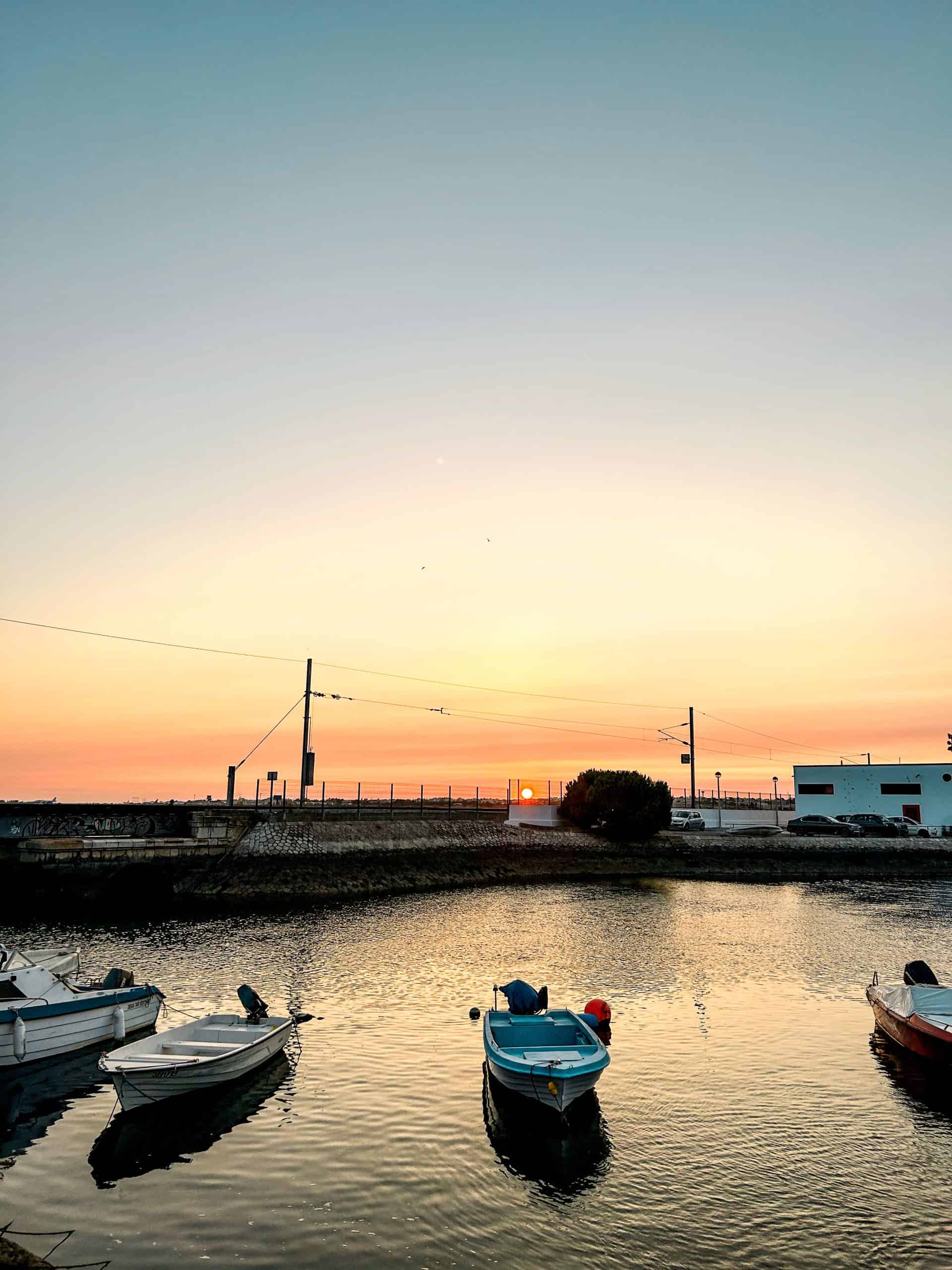 boats in the harbor in Faro, Portugal at sunset