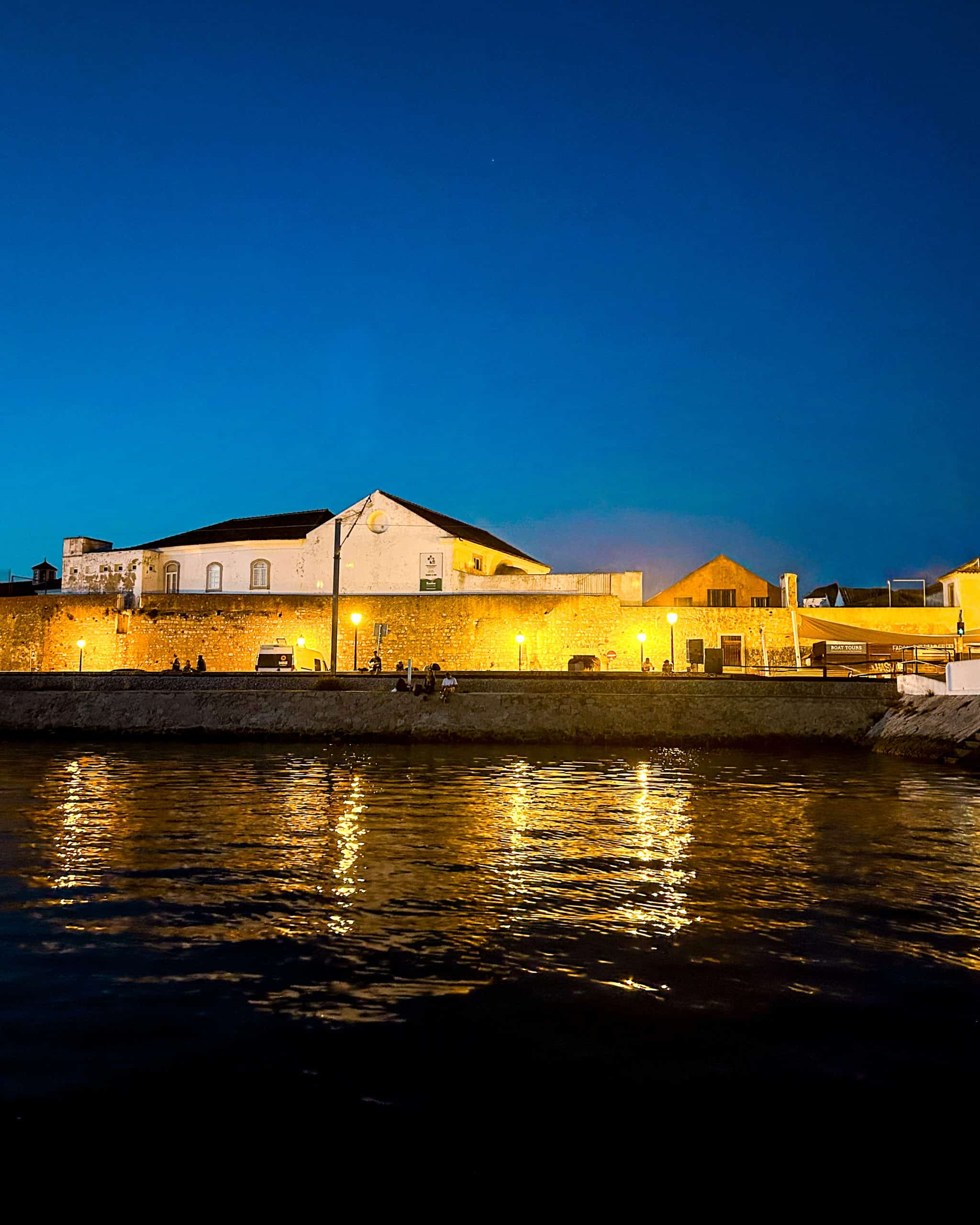 old building in Faro, Portugal near the water with lots of lights at night