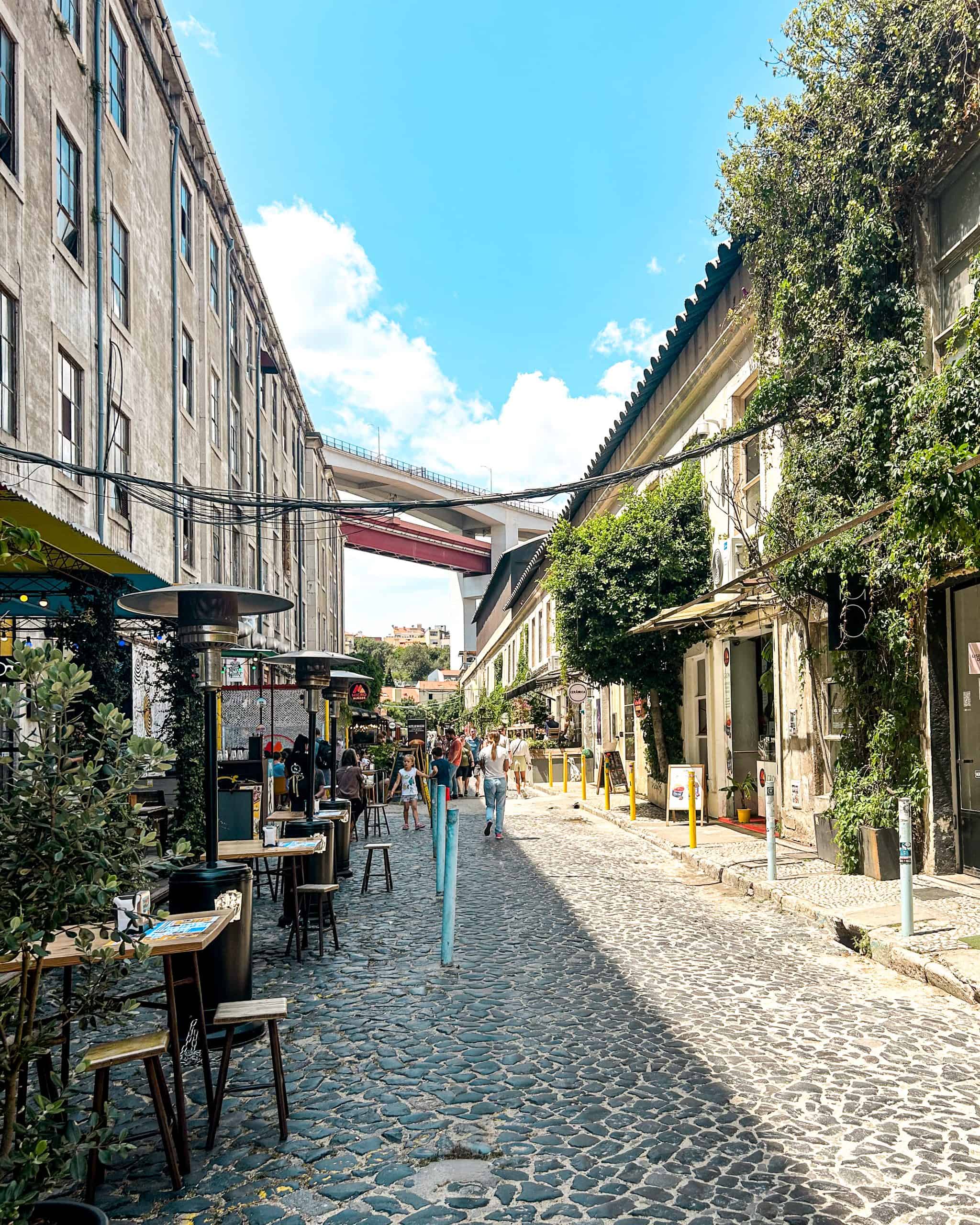 Trendy LX Factory street filled with cafés, shops, and people exploring Lisbon, Portugal