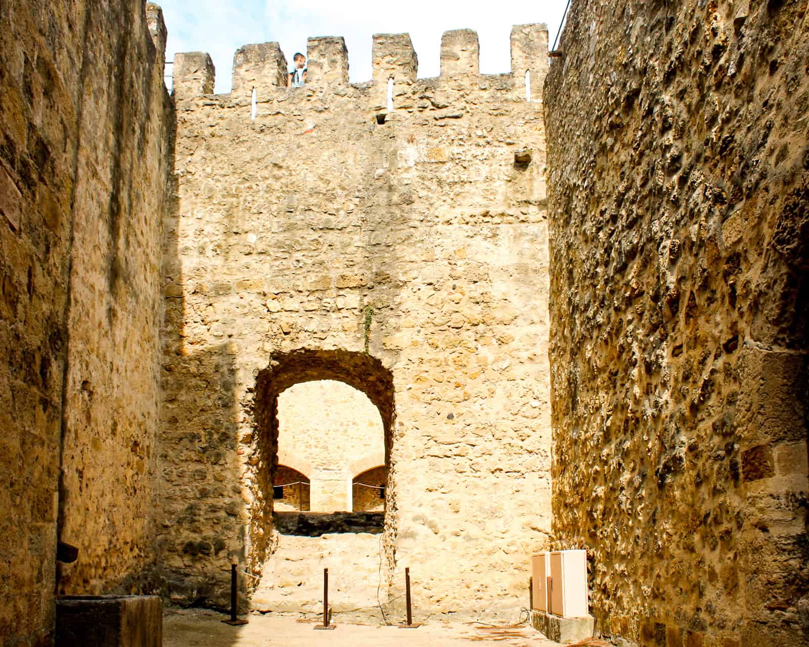 Stone walls and archway inside São Jorge Castle, one of Lisbon, Portugal’s historic landmarks