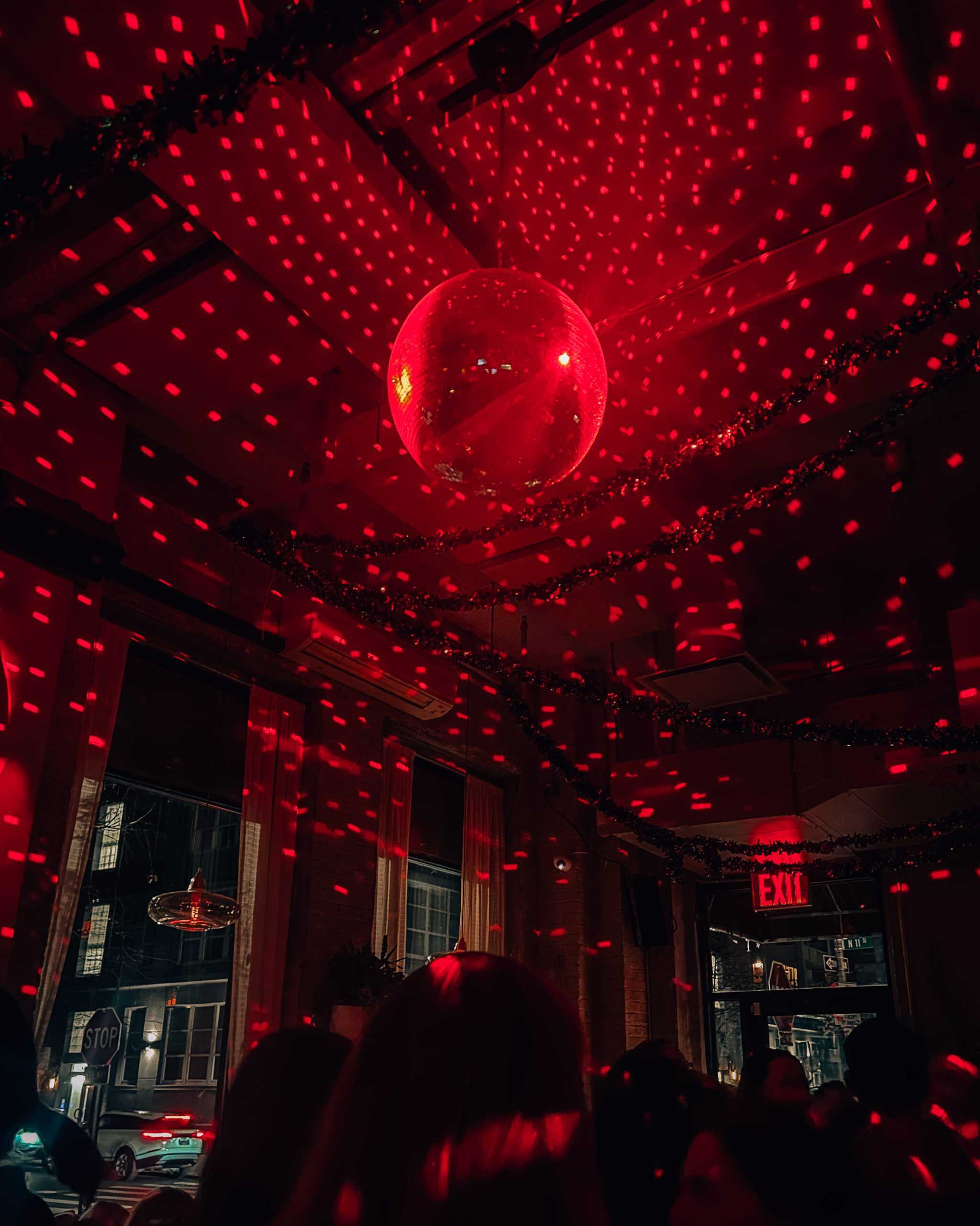 disco ball with red lights at a bar in NYC at night