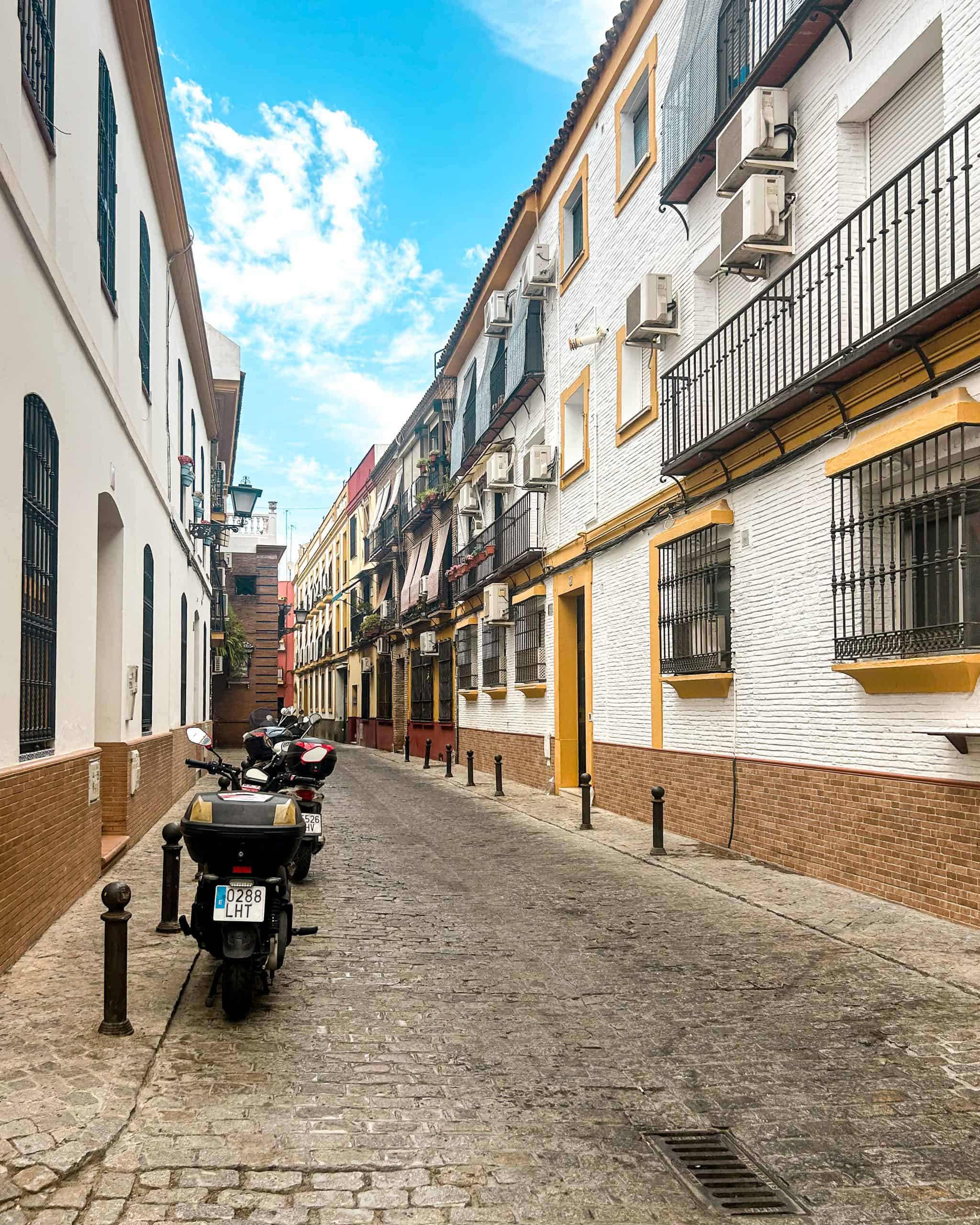 empty narrow alleyway in Seville, Spain with scooters