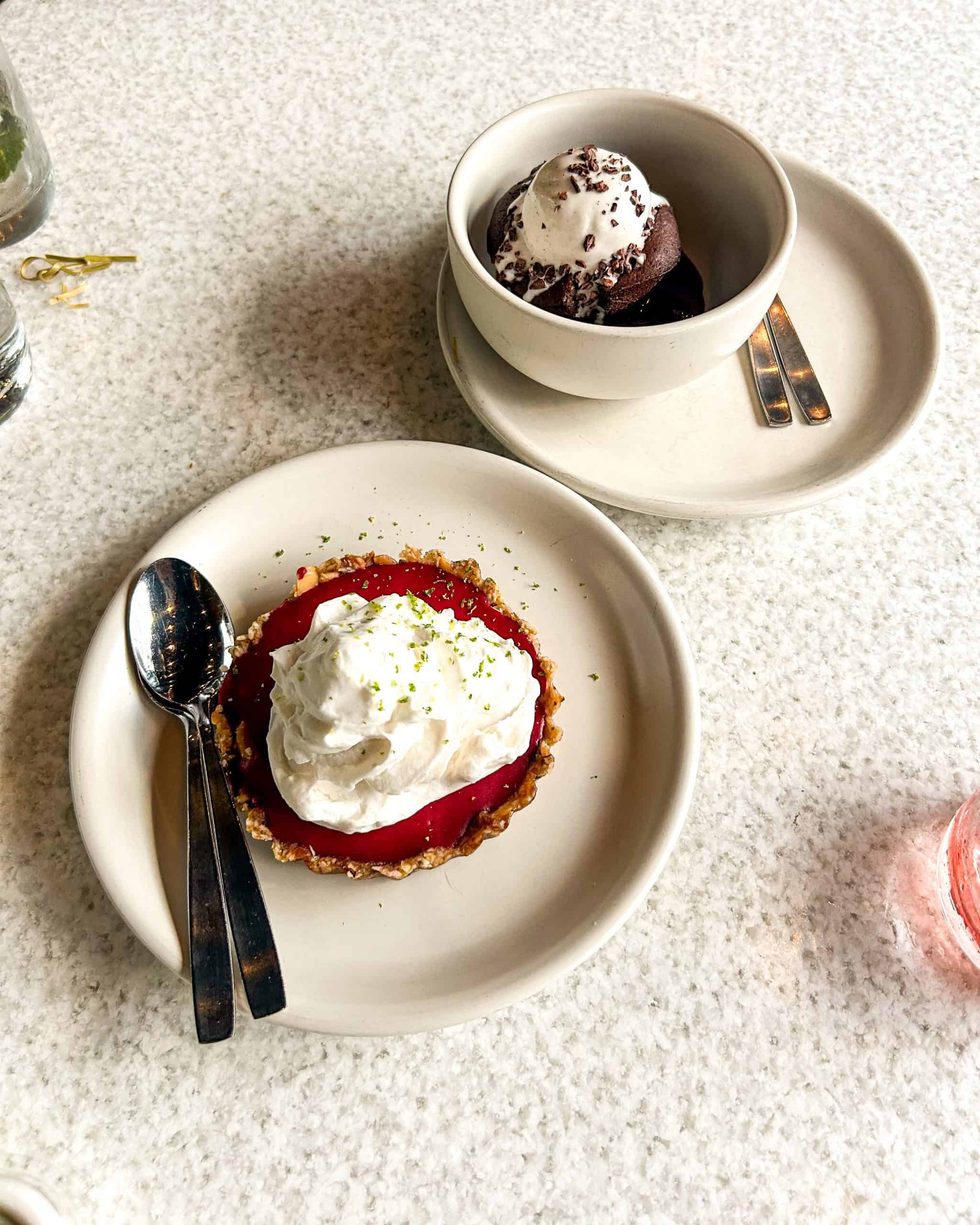 Elegant dessert spread at a modern restaurant in Denver, Colorado, featuring fruit tart, chocolate dessert, and minimalist table setting