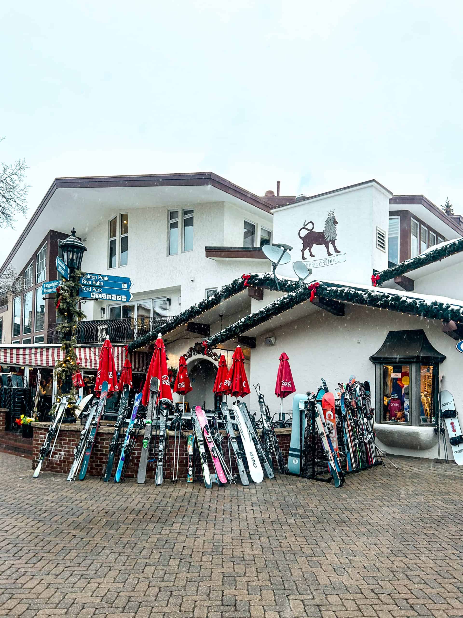 Skis and snowboards lined up in Vail Village with alpine architecture and winter decorations in the Vail Village in Colorado