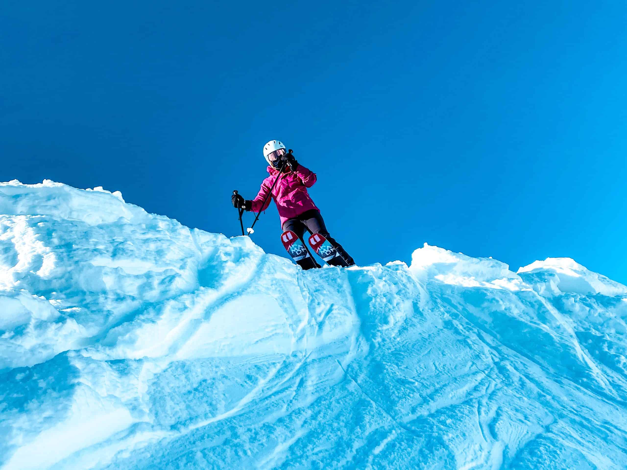 Skier standing on a snowy ridge in Vail, Colorado with dramatic blue skies 