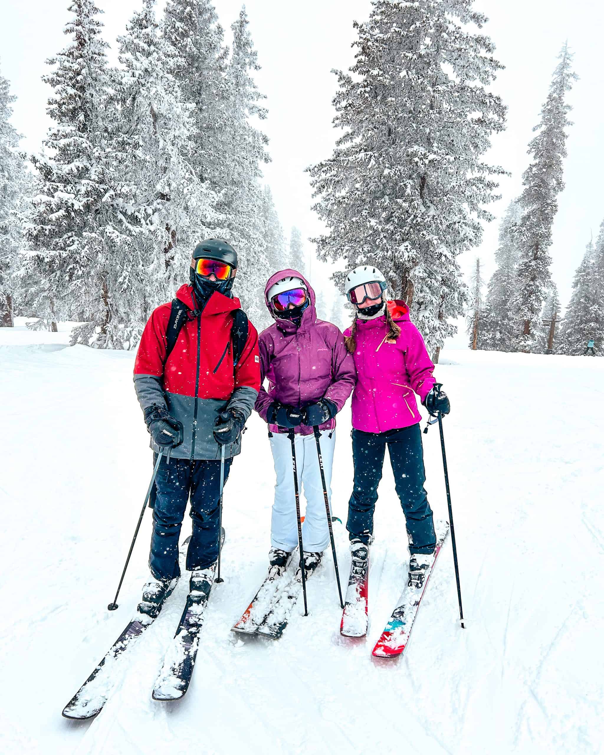 Group of skiers posing on a snowy trail in Beaver Creek, Colorado surrounded by pine trees