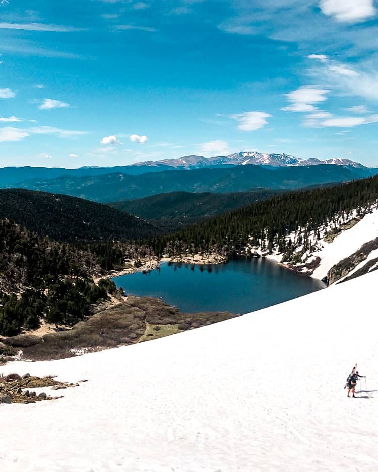 Alpine lake and snow-covered slope near St. Mary’s Glacier, a high-alpine day trip from Denver.
