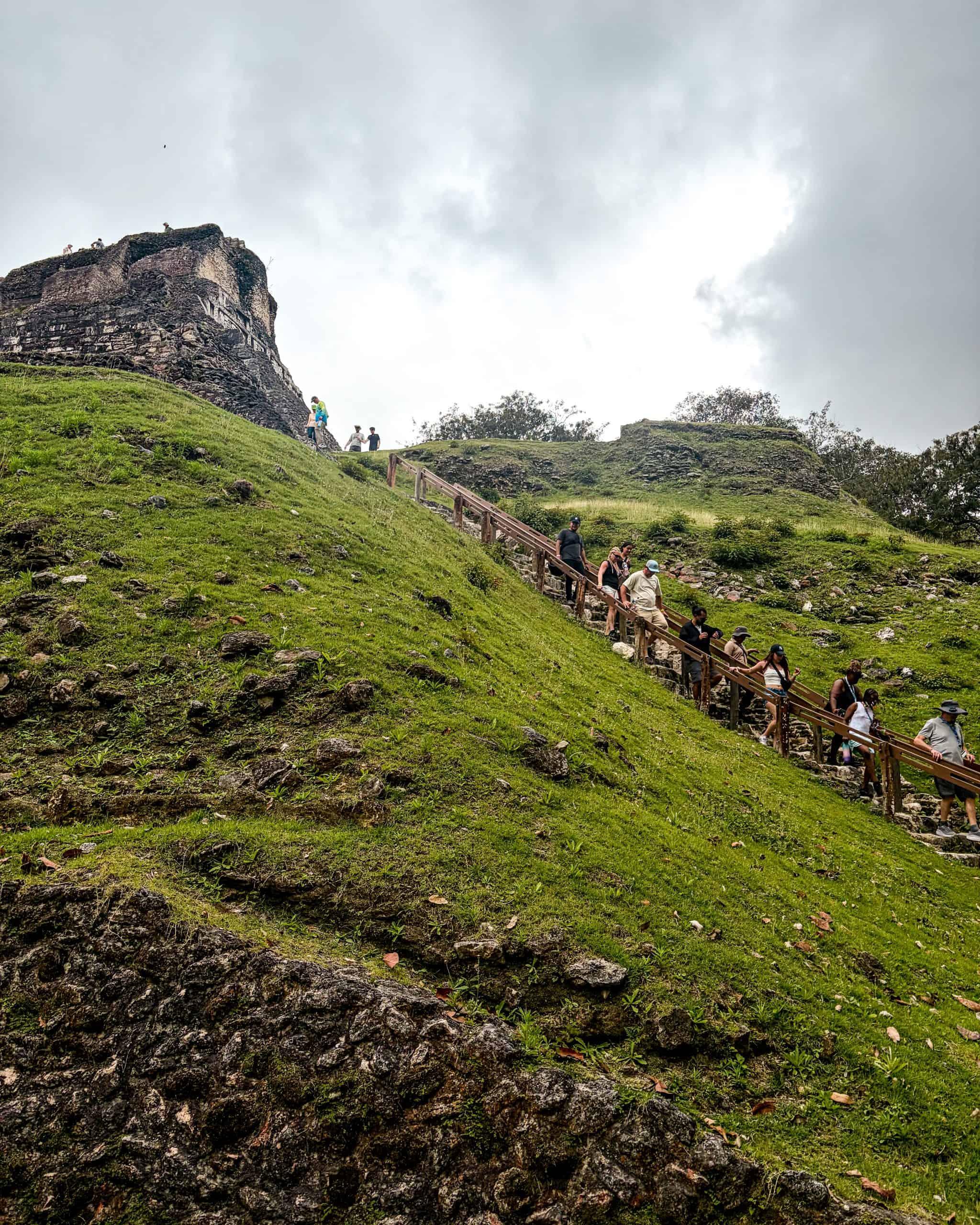 Four visitors descending the stone staircase at Xunantunich, a Mayan ruin in Belize