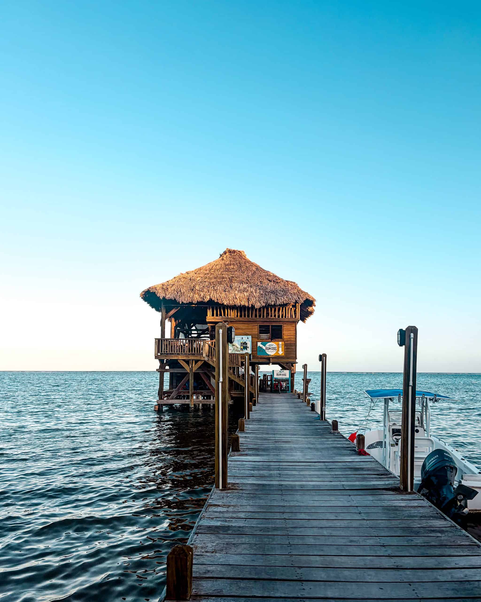 Rum Dog restaurant extending over the water on a dock at dusk in San Pedro, Belize