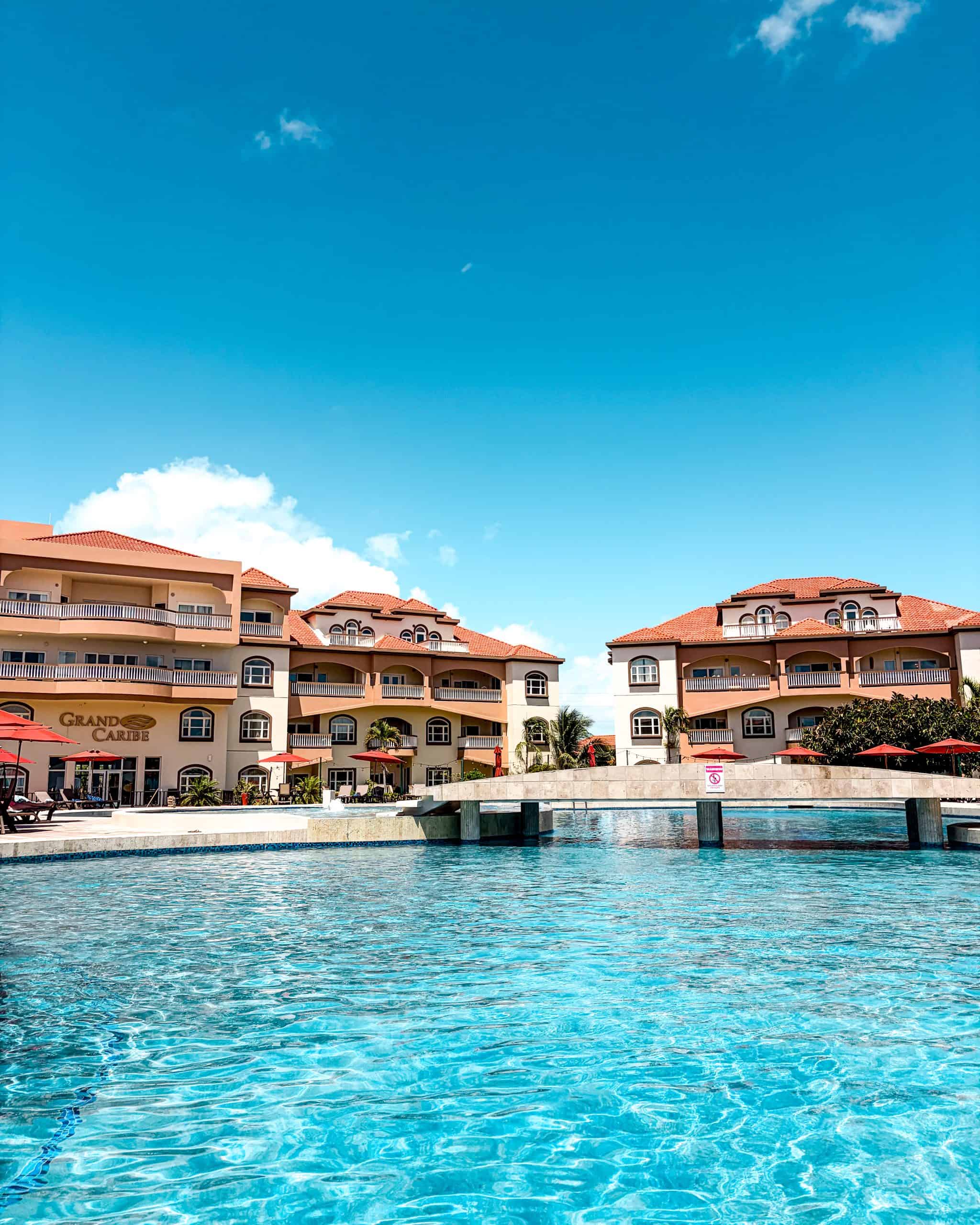 Grand Caribe resort pool with a swim-up bar surrounded by tall palm trees