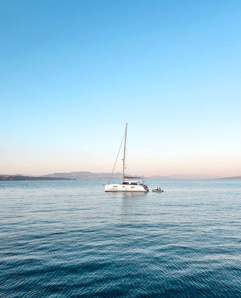 A sailboat on calm water at sunset