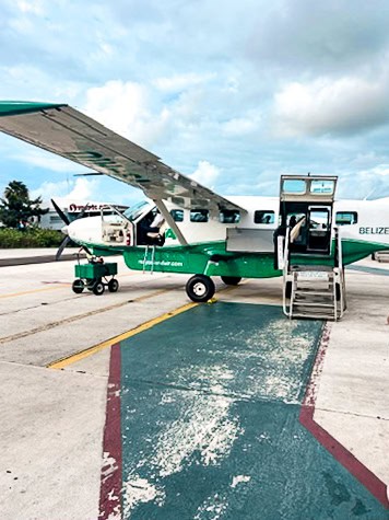 A small propeller plane sits on the tarmac at San Pedro's local airstrip